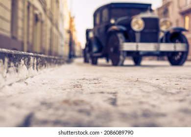 Winter in the city. The car is parked at the sidewalk. Antique car. Historical center of the city. Frosty snowy day. Focus on the road. Close up view from the level of the road. - Powered by Shutterstock