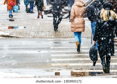 Winter City Slippery Sidewalk. Back View On The Feet Of People Walking Along The Icy Snowy Pavement. Pair Of Shoe On Icy Road In Winter. Abstract Empty Blank Winter Weather Background