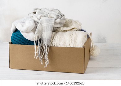 Winter Clothes In A Cardboard Box. Seasonal Clothing For Shipping Or Donation.