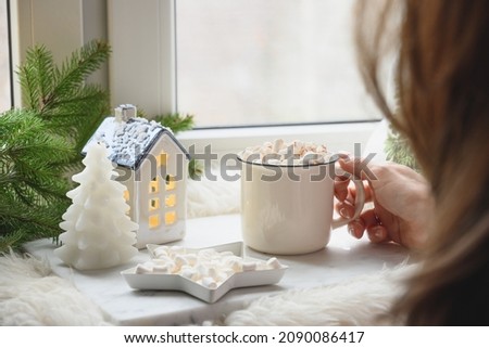 Winter coffee on window sill with Christmas decorations, cozy holiday time. Close up.