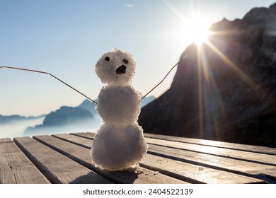 Winter is Coming Concept With Small Snowman on Wooden table in Mountains Environment - Powered by Shutterstock