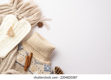 Winter Concept. Top View Photo Of Knitted Sweater Scarf Mittens Decorative Wooden Christmas Tree Shaped Clip Anise Pine Cone And Cinnamon Sticks On Isolated White Background With Empty Space