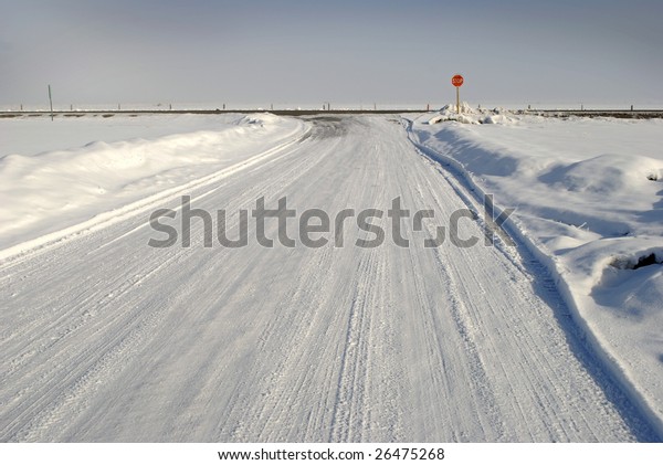 Winter\
country road with crossroad and car tracks in\
snow