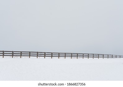 Winter Creates A Stark Cold Landscape Cut In Two By An Endless Fence.