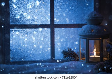 Winter decoration with a candlestick near the snow-covered window. Christmas background