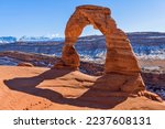 Winter Delicate Arch - A closeup view of Delicate Arch, with snow-covered La Sal Mountains towering in background, on a clear sunny Winter day. Arches National Park, Utah, USA. 