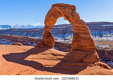 Winter Delicate Arch - A closeup view of Delicate Arch, with snow-covered La Sal Mountains towering in background, on a clear sunny Winter day. Arches National Park, Utah, USA.  - Shutterstock ID 2237608131