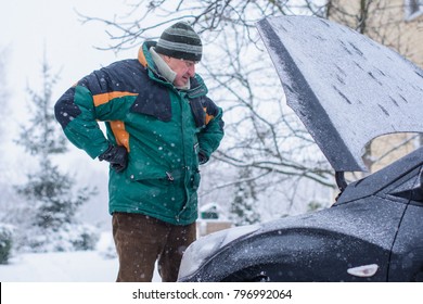 Winter Difficulties With The Car, Problems Due To Bad Weather Conditions. Unrest On The Road En Route. The Man Is Trying To Get Out Of The Problem And Trouble Situation With The Car