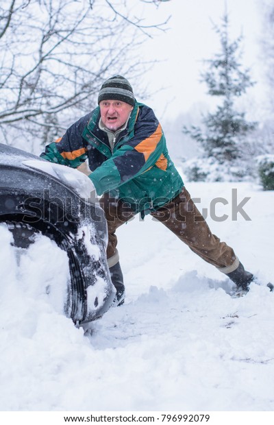 Winter\
difficulties with the car, problems due to bad weather conditions.\
Unrest on the road en route. The man is trying to get out of the\
problem and trouble situation with the\
car
