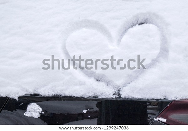 Winter. Drawn heart on a\
car windscreen