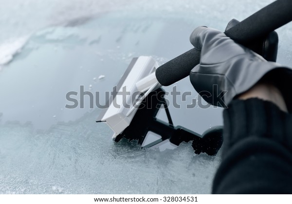 Winter\
Driving - Woman Scraping Ice from a\
Windshield