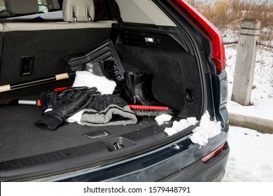 winter emergency automobile kit, hat, gloves, scarf, boots in the trunk - Shutterstock ID 1579448791