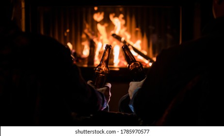 Winter Escape - Friends Relax By The Fireplace With Beer In Their Hands