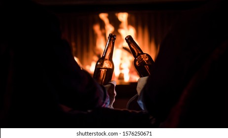 Winter Escape - Men Relax By The Fireplace With Beer In Their Hands