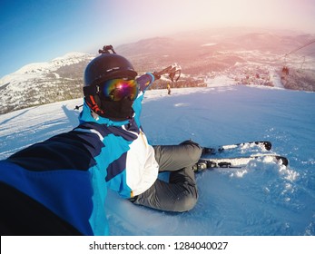 Winter Extreme Sport With Selfie Action Camera. Man Rides On Slopes Skis In Protective Helmet.