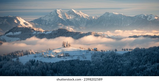 Winter fairytale in Slovenia - a foggy snowy sunrise in a countryside landscape with the church of Sveti Tomaz - Powered by Shutterstock