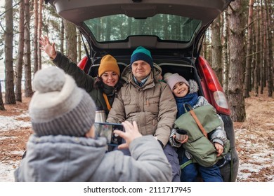 Winter Family Road Trip. Happy Parents With Kids Make Photo In The Trunk Of Car During Walking In Snowy Pine Forest, Travel Together In Any Season, Active Lifestyle, Authentic People