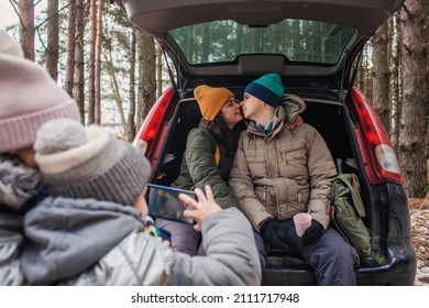 Winter Family Road Trip. Happy Parents With Kids Make Photo In The Trunk Of Car During Walking In Snowy Pine Forest, Travel Together In Any Season, Active Lifestyle, Authentic People