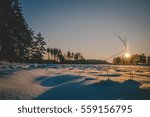 Winter fields sunset with snow and with shadows from snow drifts. Colorful landscape of sunset in winter.