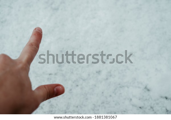 Winter. the\
finger points at the snow in\
close-up.