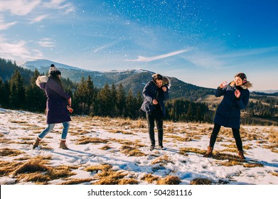Winter friends play in the snow in the mountains