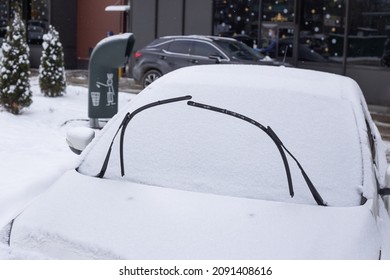 Winter frosty car windshield. Snowstorm in city.
