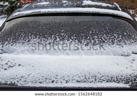 Winter frozen back car window, texture freezing ice glass background
