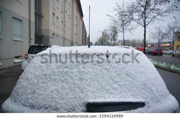 Winter frozen back car window, texture freezing
ice glass background. morgen scene. night snowfall. Frozen rear
window of the car, covered with  snow on a winter day. Close up
image.