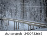 Winter frozen landscape with snowy bridge and icy water. Winter landscape with frozen bridge railings and snowy wires.