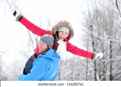 Winter Fun Couple Playful Together During Winter Holidays Vacation Outside In Snow Forest. Happy Young Interracial Couple, Asian Woman, Caucasian Man.