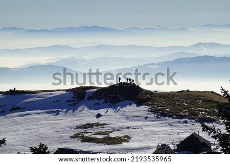 Winter fun. A group of hikers enjoying the snow-covered hills of Velika Planina, Slovenia.