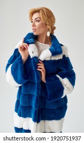 Winter Girl  In Luxurious Fur Coat. Fashion Model Posing In White Background A Fur Chinchilla Coat. Studio Shot .