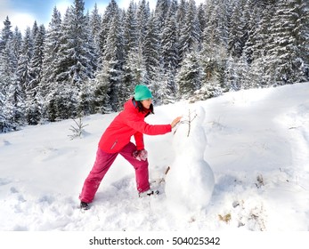 Winter Girl Making A Snowman