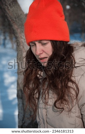 winter girl in orange warm hat in snow wintertime. winter fashion of girl in warm hat with wintertime snow.