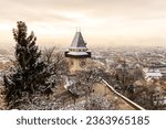 Winter in Graz, with the Uhrturm and Schloßberg covered with snow during sunrise