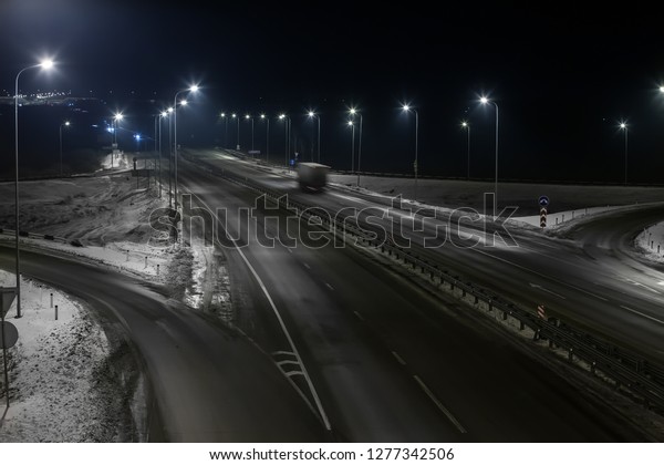 winter highway at\
night shined with lamps