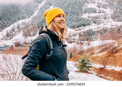 Winter Hike On Snow Mountain Young Happy Hiker Woman Climbing. Europe Travel Adventure Trek In Nature Landscape. Young Cheerful Female Wearing Yellow Hat, Black Jacket For Cold Weather And Bag.