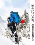 Winter hiking in the mountains with a backpack and snowshoes.