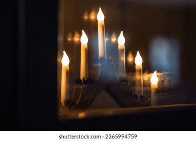 winter holidays and celebration concept - close up of advent candlestick on window sill at night