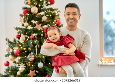 winter holidays and family concept - happy middle-aged father and baby daughter over christmas tree at home - Powered by Shutterstock