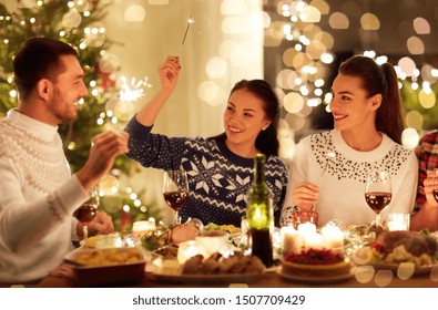 Winter Holidays And People Concept - Happy Friends With Sparklers Celebrating Christmas At Home Feast