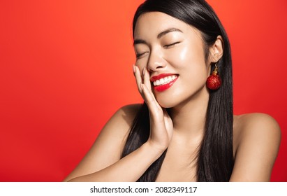 Winter Holidays, Sale And Fashion Concept. Beautiful Asian Female Model With Red Lips, Clear Facial Skin, Laughing And Smiling, Touching Healthy Glowing Face With Satisfaction