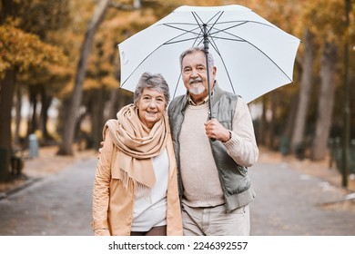 Winter, hug and senior couple in a park, retirement date and walking in Canada with an umbrella. Nature affection, smile and portrait of an elderly man and woman on a walk for happiness and love - Powered by Shutterstock