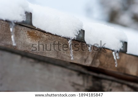 Winter icicles hanging from eaves of roof
