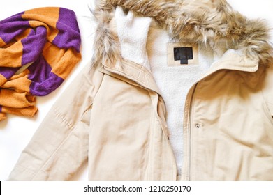 Winter jacket with faux fur and an orange and purple wool scarf. Flat lay women's outfit. Top view photo