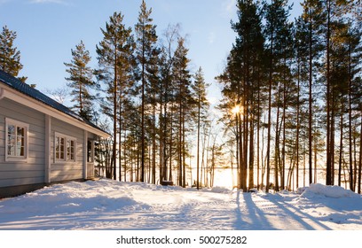 Winter lake in forest with house