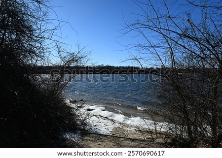 Similar – Image, Stock Photo Partly frozen lake with a view of the snow-covered fir forest