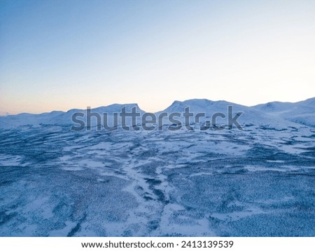 Winter Landscape at Blue Hour Snowy Terrain and Mountain Silhouettes





