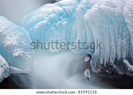 Winter landscape of cascade framed by blue ice and captured with motion blur, Gull Creek, Michigan, USA
