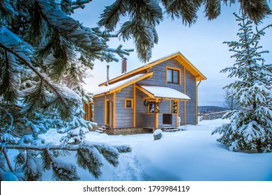 Winter landscape. Cottage on the background of snow-covered fir branches. Wooden house in the countryside. Christmas and New year in cottages. Rent a country house for a large company.